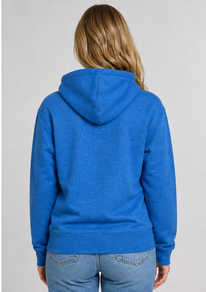 A woman viewed from the back wearing a heather blue pullover hoodie and light blue jeans against a plain light gray studio background.