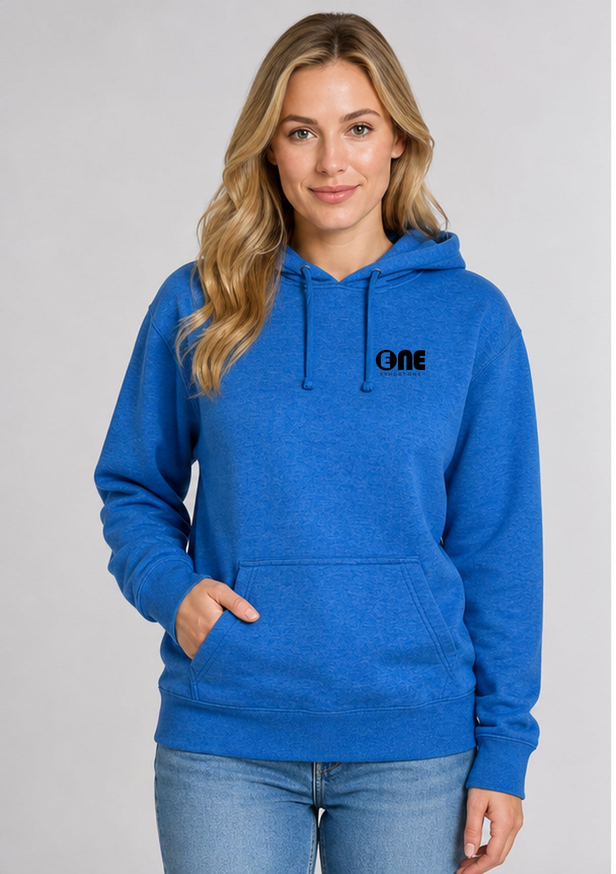 A woman wearing a bright blue heather pullover hoodie with a black 'ONE' logo on the left chest, paired with light blue jeans, photographed against a neutral gray studio background.